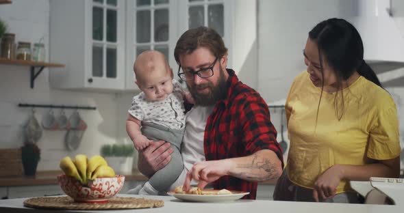 Young Couple Having Breakfast with Their Baby