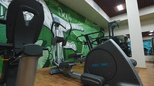 Elliptical Training Machine Near Green Wall in Light Gym