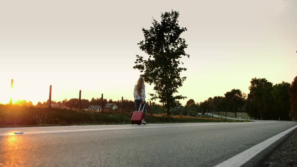 Cheerful Woman with Suitcase Walking on Road