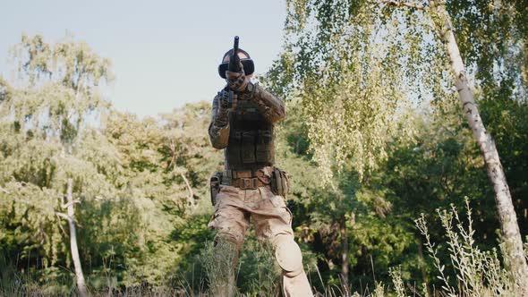 Soldier with Rifle Wearing Virtual Reality Glasses Outdoors