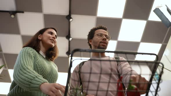 Multiracial Couple Filling Grocery Cart in Shop