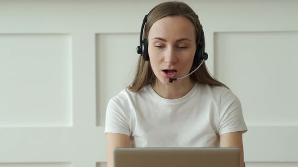 Female Operator Working with Headset and Laptop in Call Center