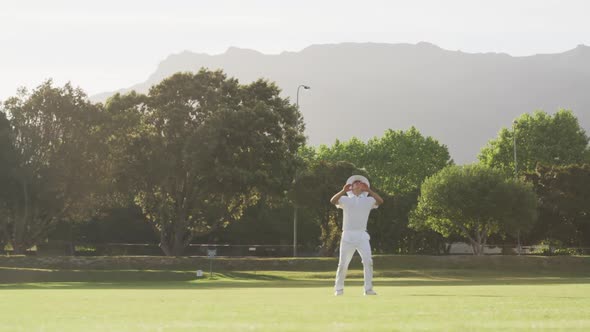 Cricket player catching the ball on the pitch