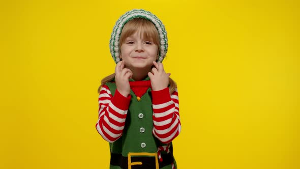 Christmas wish concept Kid teen girl in Christmas elf Santa helper costume making a wish, prays