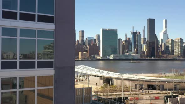 An aerial view from Queens, NY on a sunny day with blue skies. The drone camera is up close to a new