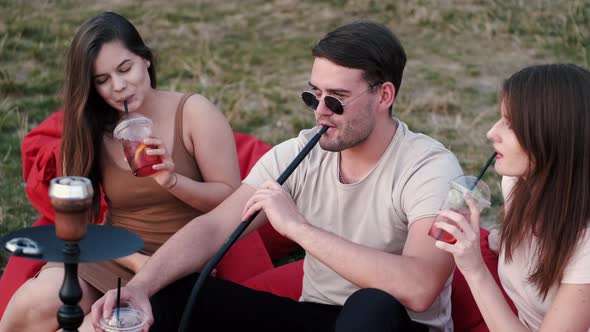 The Young Man Smoking Hookah and Ladies Are Having Fun