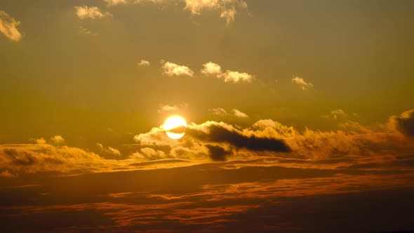 Amazing Sunset Through the Cumulus Clouds in the Orange Sky