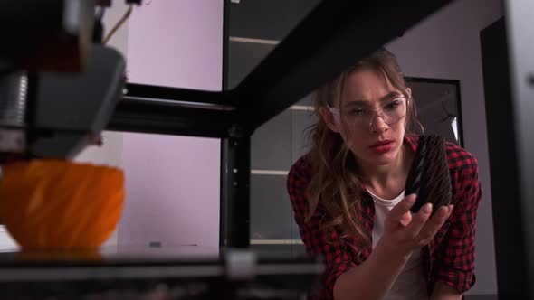 A Female Student in a Modern Classroom Observing the Printing Process of a 3d Model