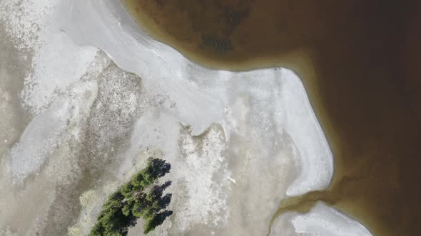 Looking down at sandbar along stagnant water