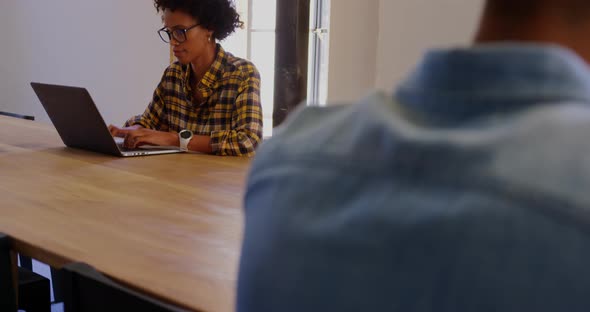 African American Businesswoman using laptop in a modern office 4k