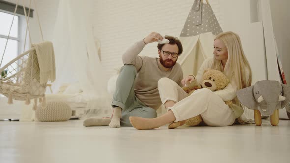 Married Caucasian Soontobeparents Couple Sitting in Their Future Newborn's Room and Chatting About