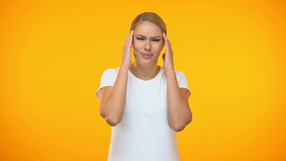 Young Lady Suffering Headache on Bright Background, Temple Spasm, Health Care