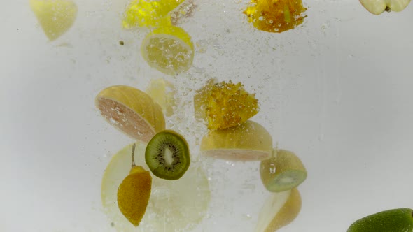 Sectioned fruits dropped into water, Ultra Slow Motion alt