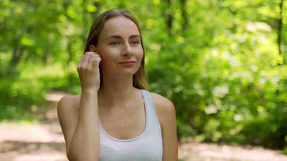 Young Girl Is Put on Earphones and Runing in Park in Summer, Healthy Lifestyle.