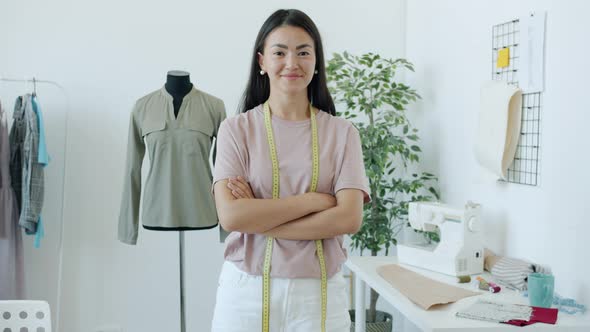 Portrait of Happy Young Asian Lady Fashion Designer Smiling Standing in Workshop Alone