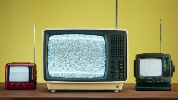 Old Televisions with Grey Interference Screen on Yellow Background