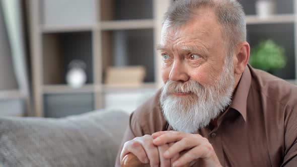 Upset 80s Grandfather Depressed Pensive Holding Cane Sitting on Couch Thinking About Health Problem