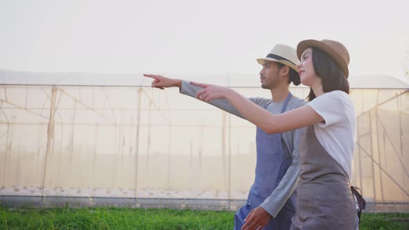 Asian business couple farmers owner working in vegetables hydroponic farm and walk with happiness.