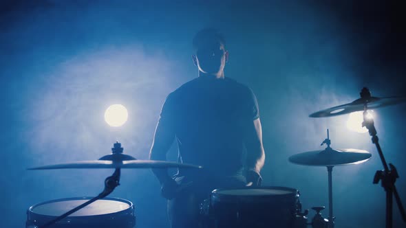 Silhouette of Professional Drummer Plays a Drums in Smoky Studio