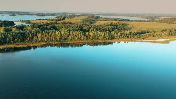 Aerial View Of Lake And Green Forest Landscape In Sunny Summer Morning