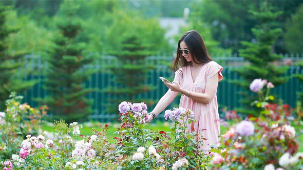 Young Girl in a Flower Garden Among Beautiful Roses, Smell of Roses