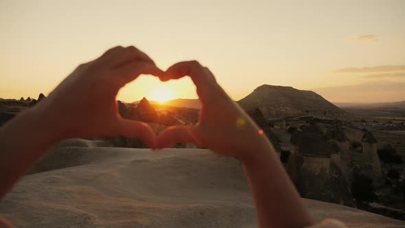 A Woman Tourist Folded Her Hands Heart Shape at Sunset