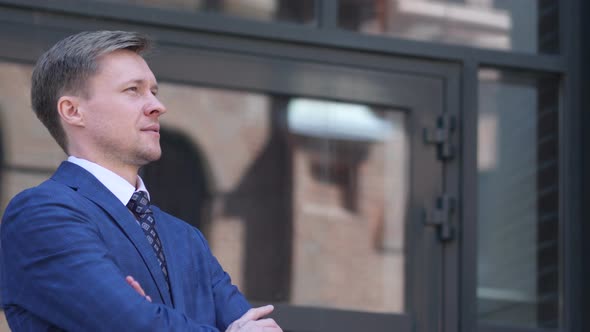 Serious Businessman Coming and Standing Outside Office