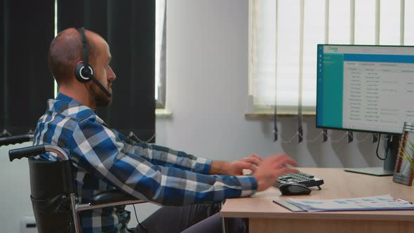 Disabled Operator Sitting in Wheelchair Making Telemarketing