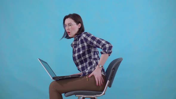 Woman Sitting Working on a Laptop Is Experiencing Pain and Discomfort From Hemorrhoids