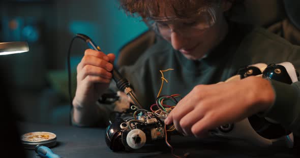 Portrait of a Boy Wearing Safety Glasses Engaged in Soldering a Robot Child Develops New Skills