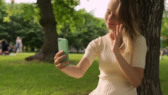 Woman with Video Call Smartphone of Screen Enjoying Social Distant in the Green Park.