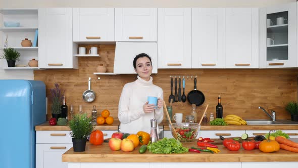 Portrait Of Young Woman Holding Cup Of Coffee In The Kitchen.