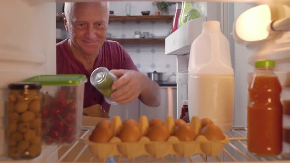 Senior Man Putting Food in Refrigerator