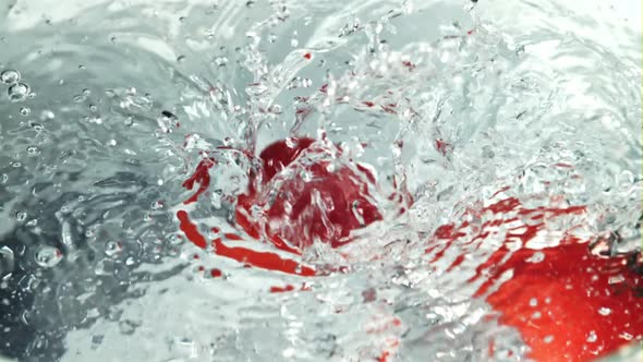 Tomatoes Fall Into Clear Water with Splashes