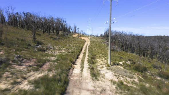 Drone aerial footage of telephone lines along a dirt track in regional Australia