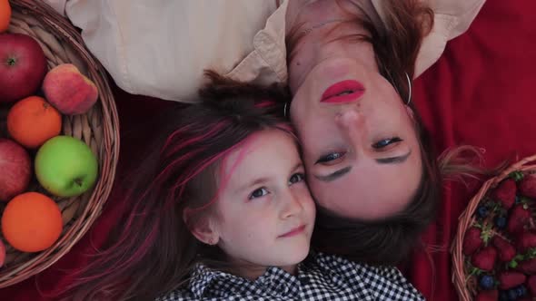 Little Girl and Her Beautiful Mother Lying on the Blanket