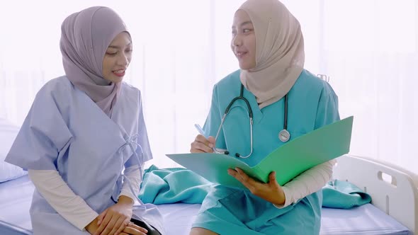 Doctor talking to young woman about her health care in hospital ward