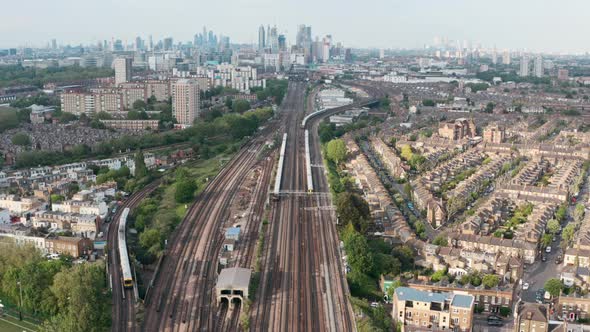 Stationary drone shot of busy British rail train tracks towards London city centre