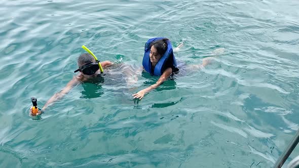 Young Girl Snorkeling with Her Father