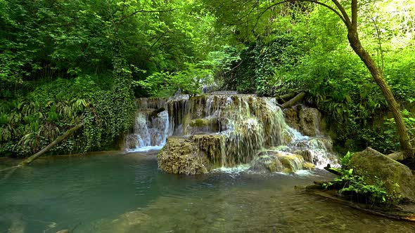 Video with a beautiful waterfall in green spring forest