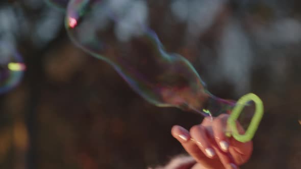 Girl Blowing Bubbles That Float Away