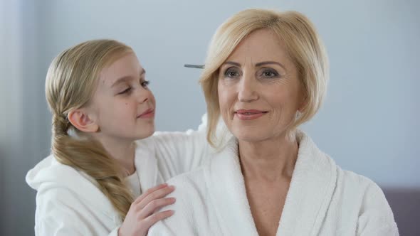 Little Female Kid Combing Grandmother Hair and Smiling, Family Relationship