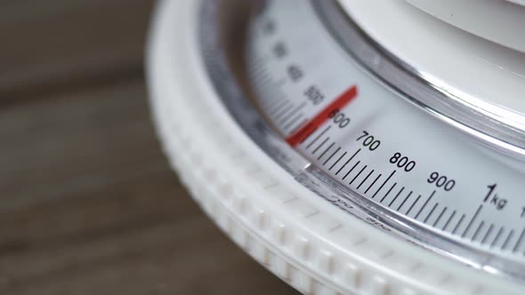 Mechanical Kitchen Scale With Dial. A White Kitchen Scale On A Wooden Table Measures 900 Grams.