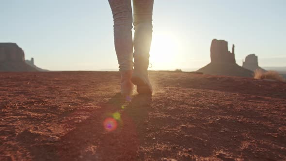 Woman Feet Walking in Hiking Boots in Desert at Golden Sunset or Sunrise  USA