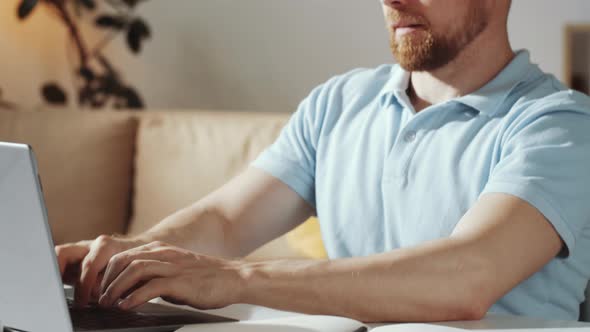 Caucasian Man Using Laptop while Working at Home