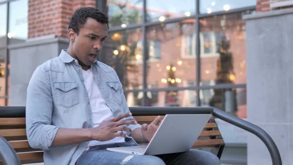 African Man Frustrated By Failure Sitting on Bench