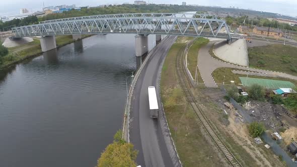 Flying over railway bridge and car traffic