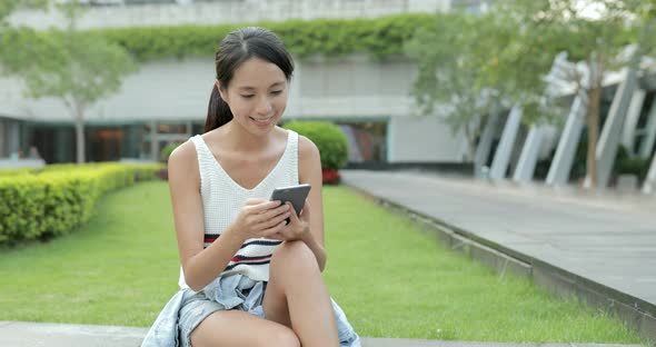 Woman looking at mobile phone in the park