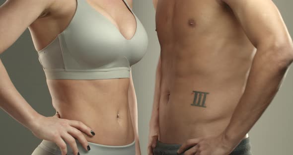 Closeup Cropped Shot of Two Bare Torsos Sportswoman in Sports Bra and Sportsman Turning Bodies at