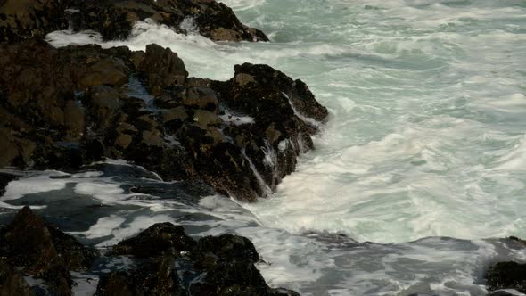 White water crashing into the rocky shoreline on the Atlantic coast CLOSE UP